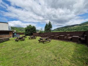a group of picnic tables and chairs in a yard at Apartment 4 Tynte Hotel. Mountain Ash. Just a short drive to Bike Park Wales in Quakers Yard +1 photo