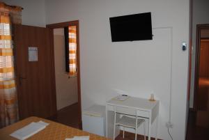 Habitación con escritorio y TV en la pared. en Hotel Ristorante Solelago en Guardialfiera