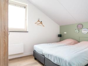 ein weißes Schlafzimmer mit einem Bett und einem Fenster in der Unterkunft Beautiful group accommodation with wellness, on a holiday park in Friesland in Akkrum