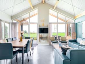 ein Ess- und Wohnzimmer mit einem Tisch und Stühlen in der Unterkunft Beautiful group accommodation with wellness, on a holiday park in Friesland in Akkrum