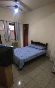 a bedroom with a bed and a tv in it at POUSADA AMAZONAS in Rio das Ostras