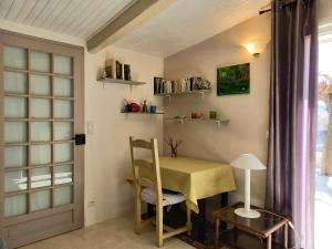 a table and chair in a room with a window at T2 de charme 55 m² au calme avec terrasse ombragée 40m2 in Carnoules