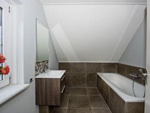 ein Badezimmer mit Waschbecken und Badewanne in der Unterkunft Stylish Stay with Garden View in Hellendoorn + 24 Fotos