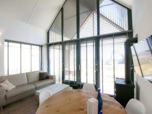 a living room with a couch and a table at Modern design lodge with combi microwave, in national park in Tholen
