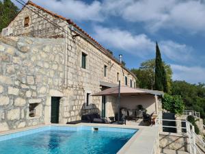 a house with a swimming pool next to a building at Amber's Place: cosy house with pool and sea views in Dubravica