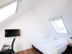 a bedroom with a bed and a tv on the wall at Modern wellness lodge with sauna in national park in Tholen