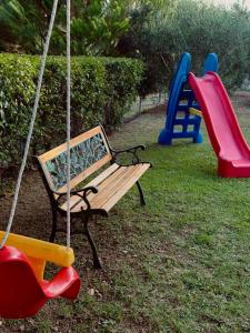 a swing in a park with two slides and a playground at Nikitihouse Apartments 1 in Nikiti