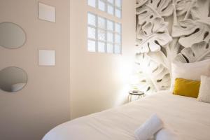 une chambre avec un lit blanc avec une tête de lit en bois dans l'établissement L Ecrin L4 3 min centre balcon, à Annecy