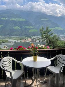uma mesa e cadeiras numa varanda com vista para as montanhas em Haus Käfersberg em Naturno