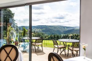 a patio with tables and chairs and a view of the mountains at The Horn Of Plenty in Tavistock