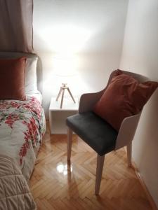 a bedroom with a chair next to a bed at Park 1 MARKO FREE PARKING in Vranje