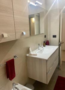 a bathroom with a sink and a toilet and a mirror at AurEdo Apartment in Muro Leccese