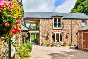 una antigua casa de ladrillo con patio en The Horn Of Plenty, en Tavistock