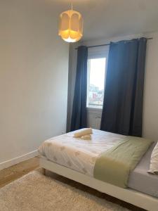- une chambre avec un lit doté de rideaux bleus et d'une fenêtre dans l'établissement AgíaHouse - Aubervilliers, à Aubervilliers