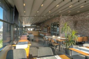 een restaurant met tafels en stoelen en een bakstenen muur bij Laren Sea Side Hotel Spa in Antalya