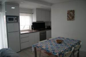 a small kitchen with a table with a table cloth on it at Aguieira STAY in Castro Daire