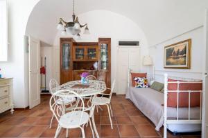Pokój ze stołem, krzesłami i łóżkiem w obiekcie Villa Boschetti Apartments w mieście Monopoli