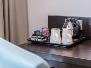 a tray with a tea kettle and cups on a table at Premier Inn Dresden City Prager Straße in Dresden
