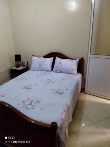 a bedroom with a bed with a floral bedspread at Appartement agadir in Agadir