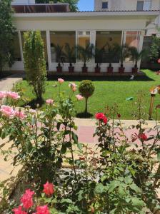 a garden with pink flowers in front of a house at Sunny House in Kranevo