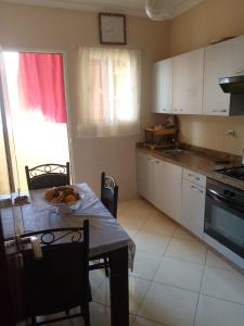 a kitchen with a table with chairs and a table and a tableablish at Appartement agadir in Agadir