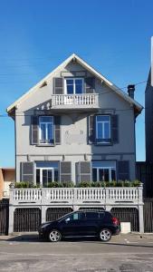 une voiture noire garée devant une maison blanche dans l'établissement Maison Berckoise Belle Époque - Plage et Centre, à Berck-sur-Mer
