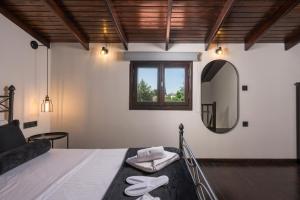 a bedroom with a bed with a mirror and a couch at Eightyfour Living with private pool in Chania