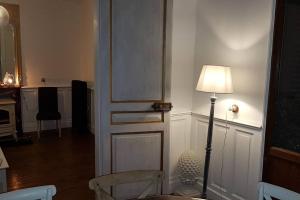 une chambre avec une porte, une lampe et une chaise dans l'établissement Maison Berckoise Belle Époque - Plage et Centre, à Berck-sur-Mer