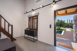 a living room with a door open to a patio at Eightyfour Living with private pool in Chania