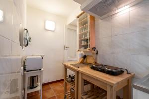 Villa Boschetti Apartments في مونوبولي: مطبخ مع طاولة خشبية في الغرفة