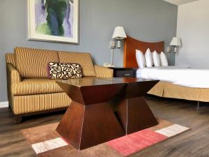 ein Hotelzimmer mit einem Sofa und einem Bett in der Unterkunft The Grand Hotel Spindletop in Beaumont
