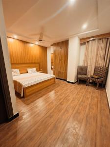 イスラマバードにあるNoors B&Bのベッドルーム1室(ベッド1台、椅子2脚付)