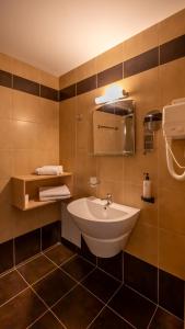 een badkamer met een wastafel en een spiegel bij Buka Sandy Beach in Messini