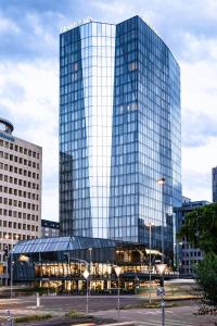 a tall glass building in a city at Grand Plaza Hotel & Congress Center in Ljubljana