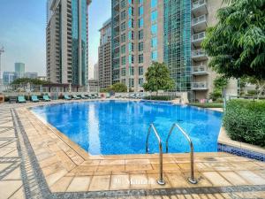 een zwembad in het midden van een stad met hoge gebouwen bij Manzil - Luxury 3BR Villa w/ maid room, Full Burj & Fountain view in Dubai