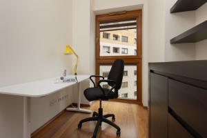 a desk and a chair in a room with a window at Apartment with Study Powstańców Śląskich by Renters in Warsaw