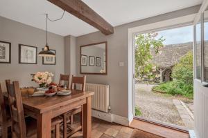 a dining room with a table and a door to a yard at Beech Cottage in Honiton