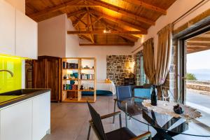 cocina y sala de estar con mesa y sillas en Stonevillas and Seaview Garden Marion en Agnándion