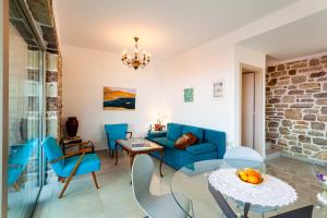 a living room with a blue couch and a table and chairs at Stonevillas and Seaview Garden Marion in Agnándion +58 photos