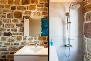 a bathroom with a sink and a shower at Stonevillas and Seaview Garden Marion in Agnándion
