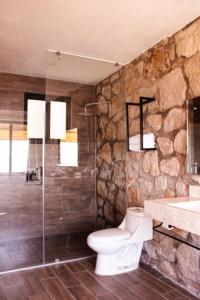 y baño de piedra con aseo y ducha. en Yauik, en Tequesquitengo