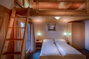 Hotel Wildbach Brienz في برينز: غرفة نوم مع سرير بطابقين وسلم