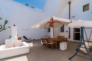 eine Terrasse mit einem Tisch und einem Sonnenschirm in der Unterkunft Residenza Celeste 3km da Gallipoli in Alezio