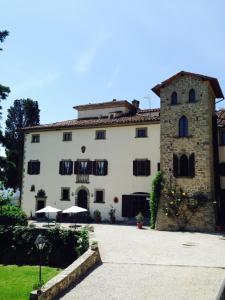 a large white building with a stone at Villa Vezza in Capolona