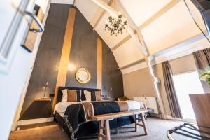 Un dormitorio con una cama grande y un banco en Hotel Montfoort en Montfoort