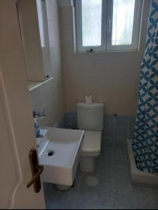 a bathroom with a toilet and a sink and a window at A Relaxing and Peace home for the best Vacation in Artemida