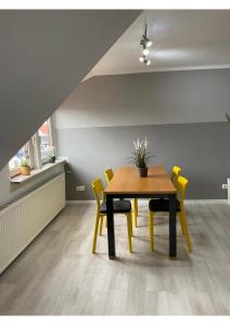 een eetkamer met een tafel en gele stoelen bij Seeadler in Bremerhaven