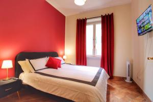 a bedroom with a bed with red walls and a tv at Charming Vatican LargeApt by YH in Rome