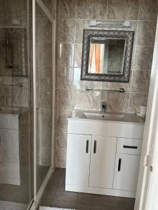 La salle de bains est pourvue d'un lavabo blanc et d'une douche. dans l'établissement Glastonbury Hotel, à Eastbourne