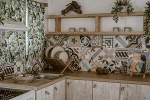 cocina con fregadero y pared de azulejos en Kanela Cottages en Alikanas